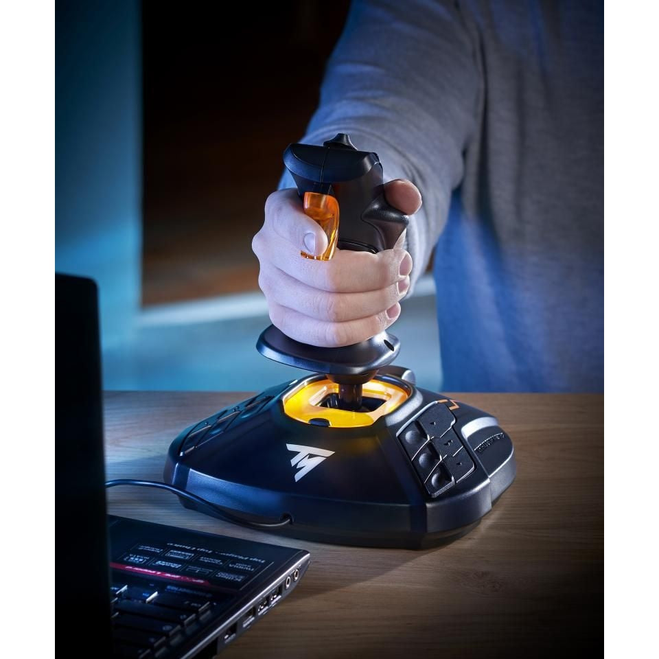 Gamer using black and orange Thrustmaster T.16000M FCS joystick at desk with laptop