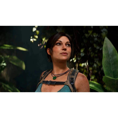 Close-up of dirt-faced Lara Croft wearing teal top and green pendant necklace