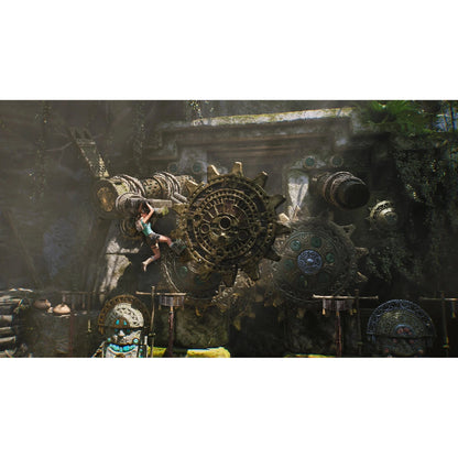 Lara Croft hanging from bronze gear mechanism in mossy stone ruin gameplay scene